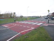 An image of a zebra crossing, facing down an empty road by Stanley High School