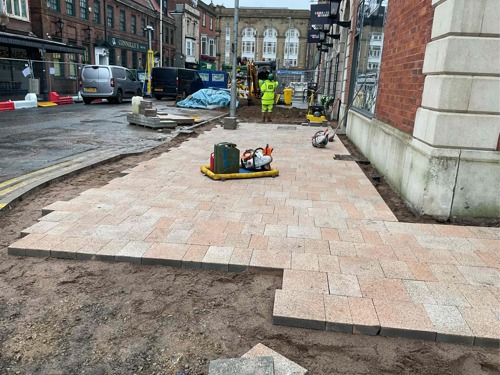 A progress picture of King Street showing new paving tiles laid down, but is still unfinished at the edge of the pavement - January 2025