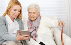 woman showing an elderly woman careline equipment