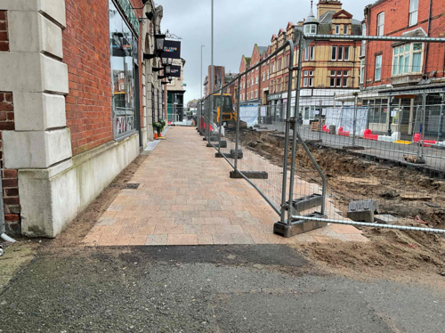 A progress picture of King Street, showing a section nearest the market complete, the drainage and middle of the road is dug up and has sand. - February 2025