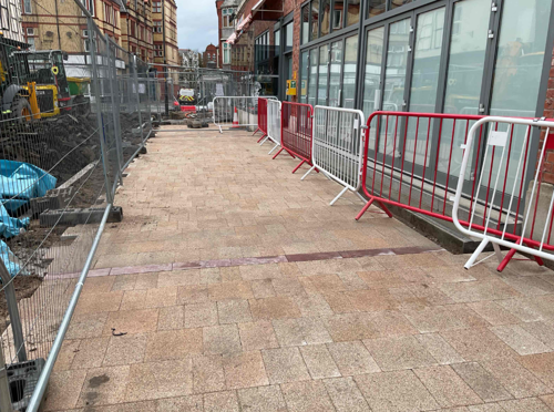 A progress picture of Market Street showing a complete part of pavement. There is fencing on both sides showing part of the road dug up - February 2025