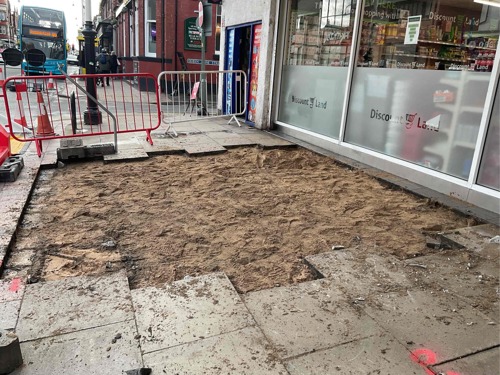 A progress picture of Eastbank Street showing paving slabs lifted and sand underneath next to Discount land - January 2025
