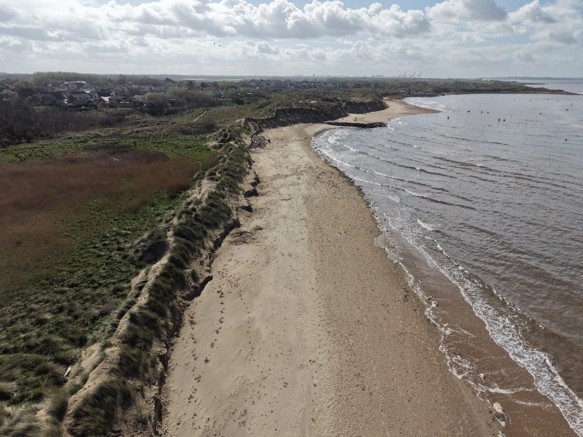 Photo taken after Storm Dave showing the erosion to the narrow dune ridge and the low flat land behind the ridge.